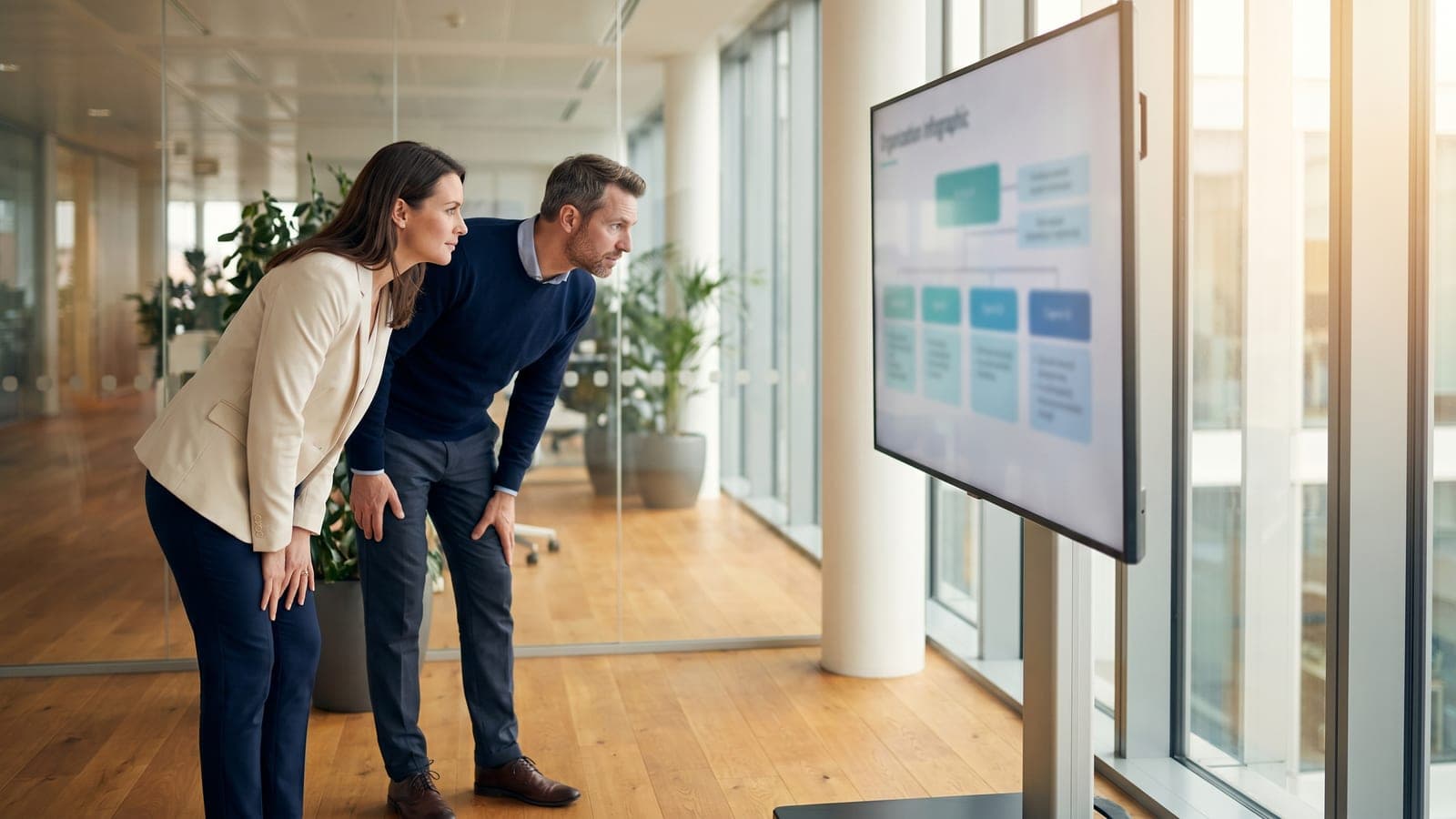 Compliance specialists reviewing a structured control catalog on a large screen.