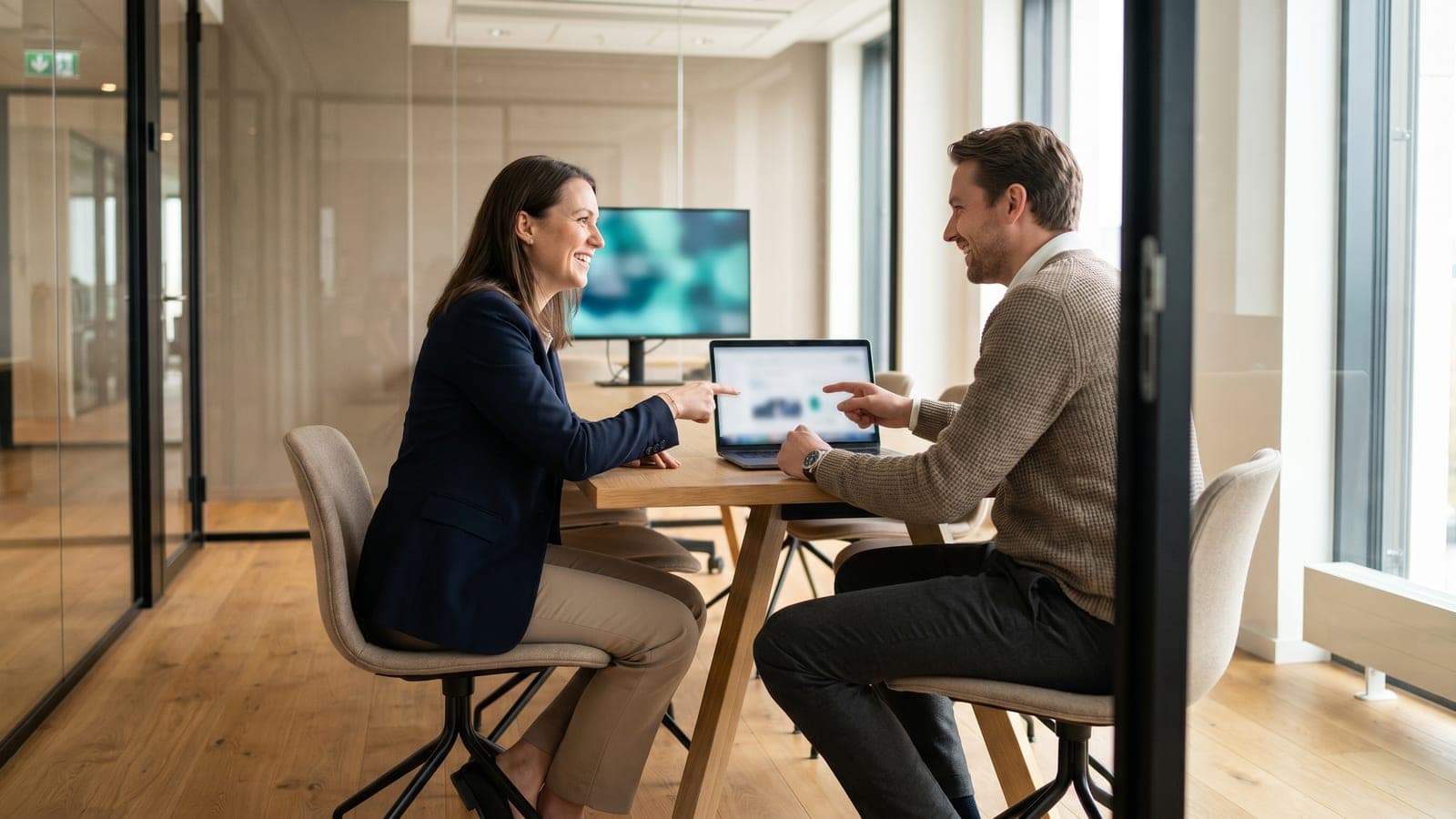 Two specialists reviewing a vendor security assessment on a laptop.
